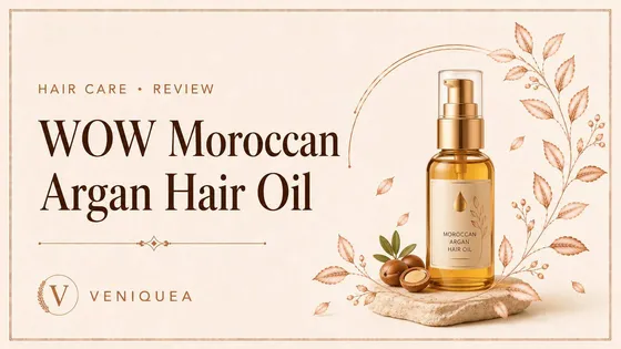 An amber argan hair-oil bottle on ivory linen with a soft leaf shadow